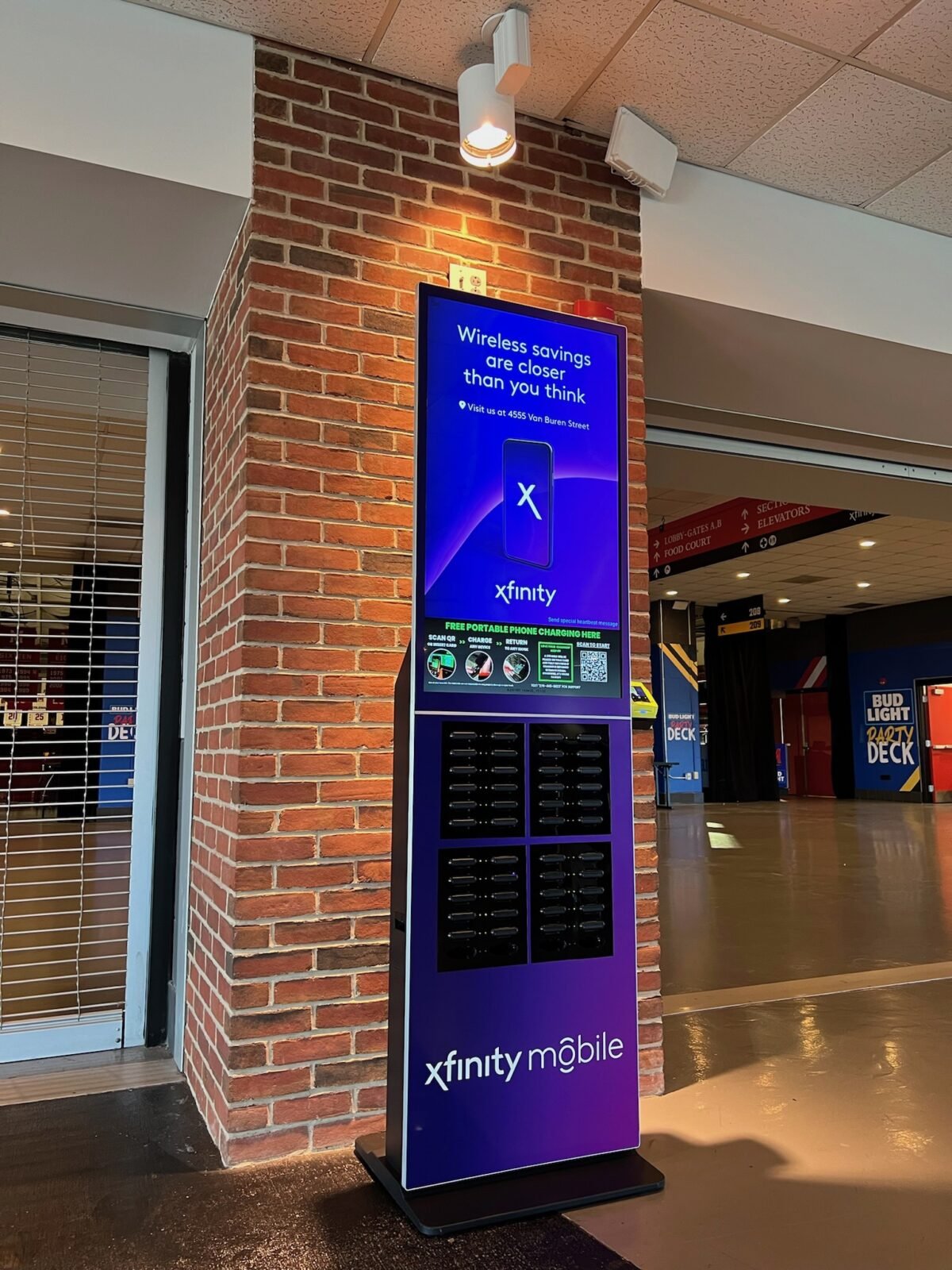 JUUCE phone-charging kiosk with Xfinity Mobile branding deployed at a stadium concourse